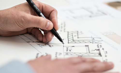 Man writing on blueprints